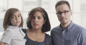 A man, a woman, and a child look at the camera in a still from "America's Dads."